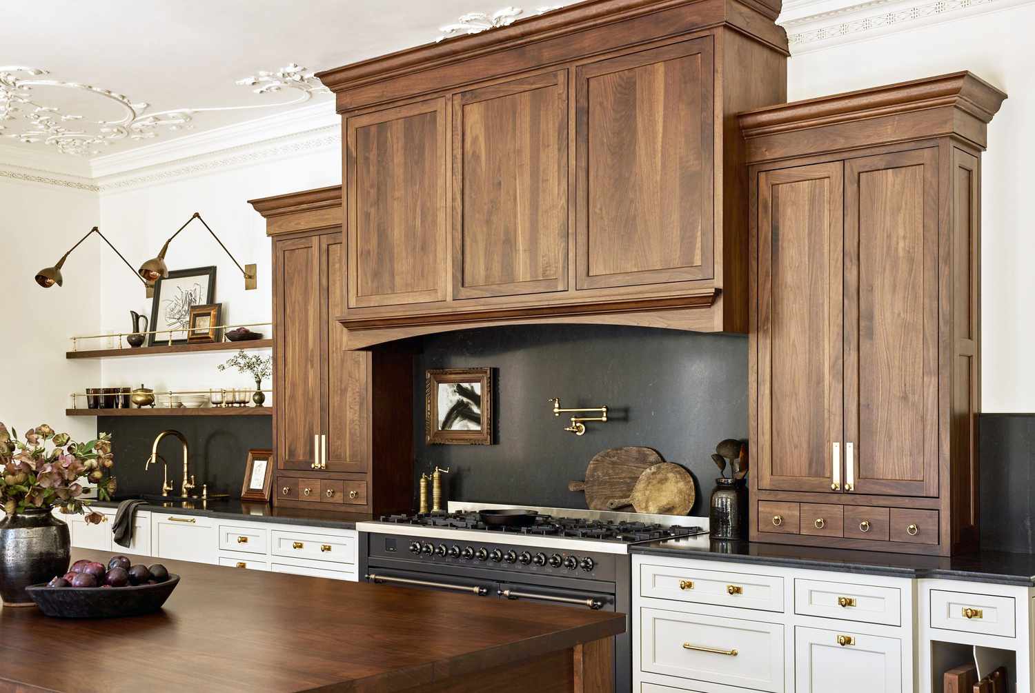 A kitchen with wooden cabinets, a black backsplash, and decorative lighting
