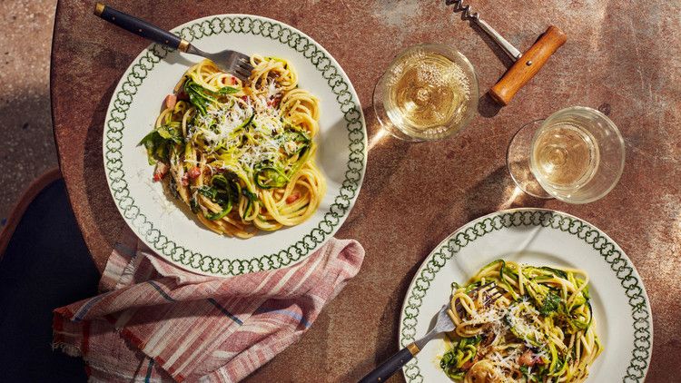 zucchini carbonara topped with fresh basil leaves
