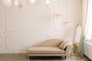 Elegant room with a chaise lounge, standing gold mirror, and chandeliers