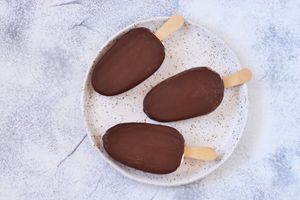 Three chocolate ice cream bars on a plate