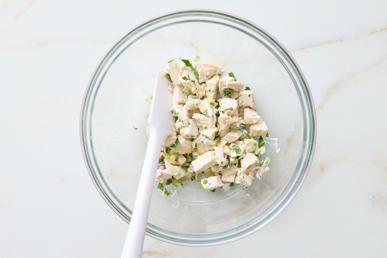 Bowl of chicken salad mixture with a spatula