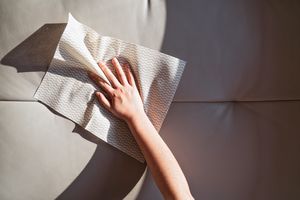 A hand cleaning a surface with a paper towel