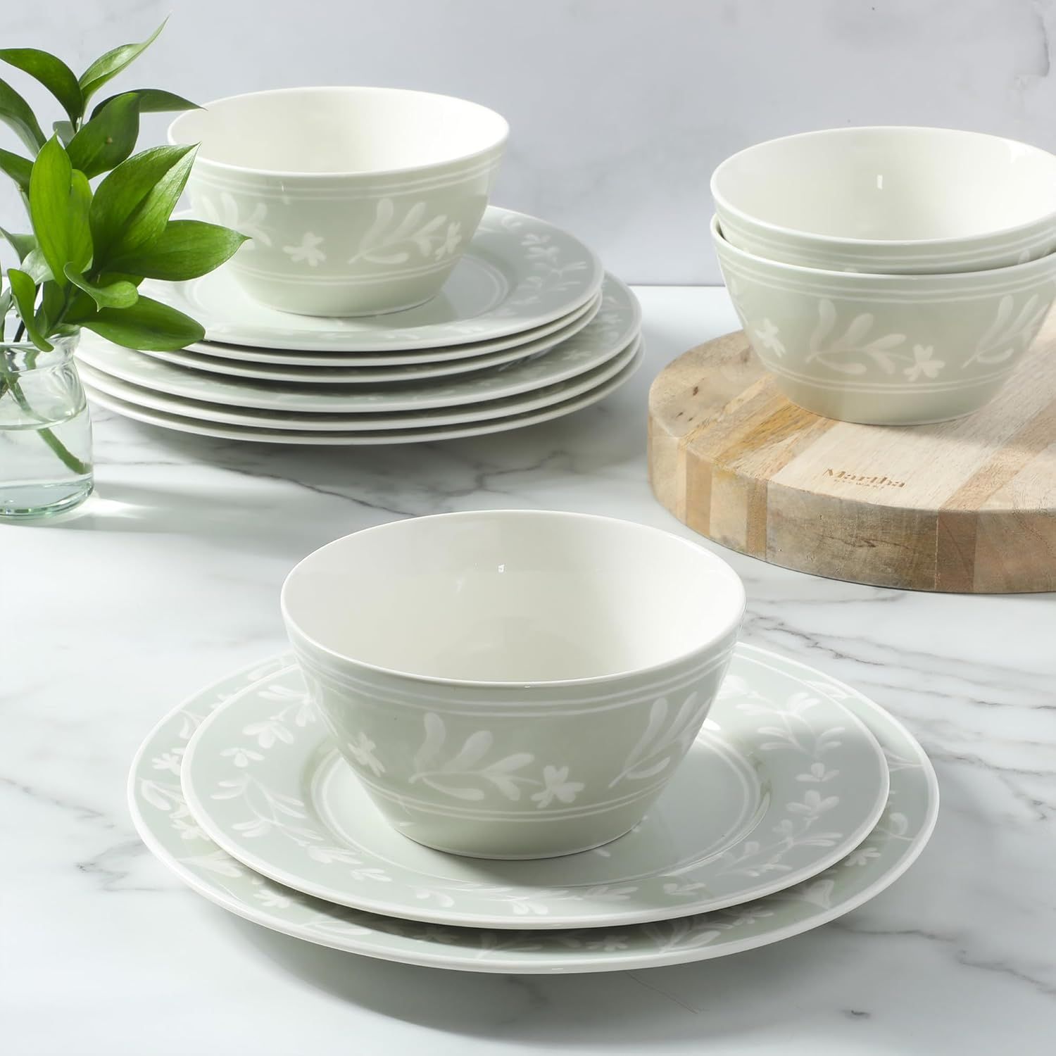 A set of ceramic dinnerware including plates and bowls with a botanical pattern