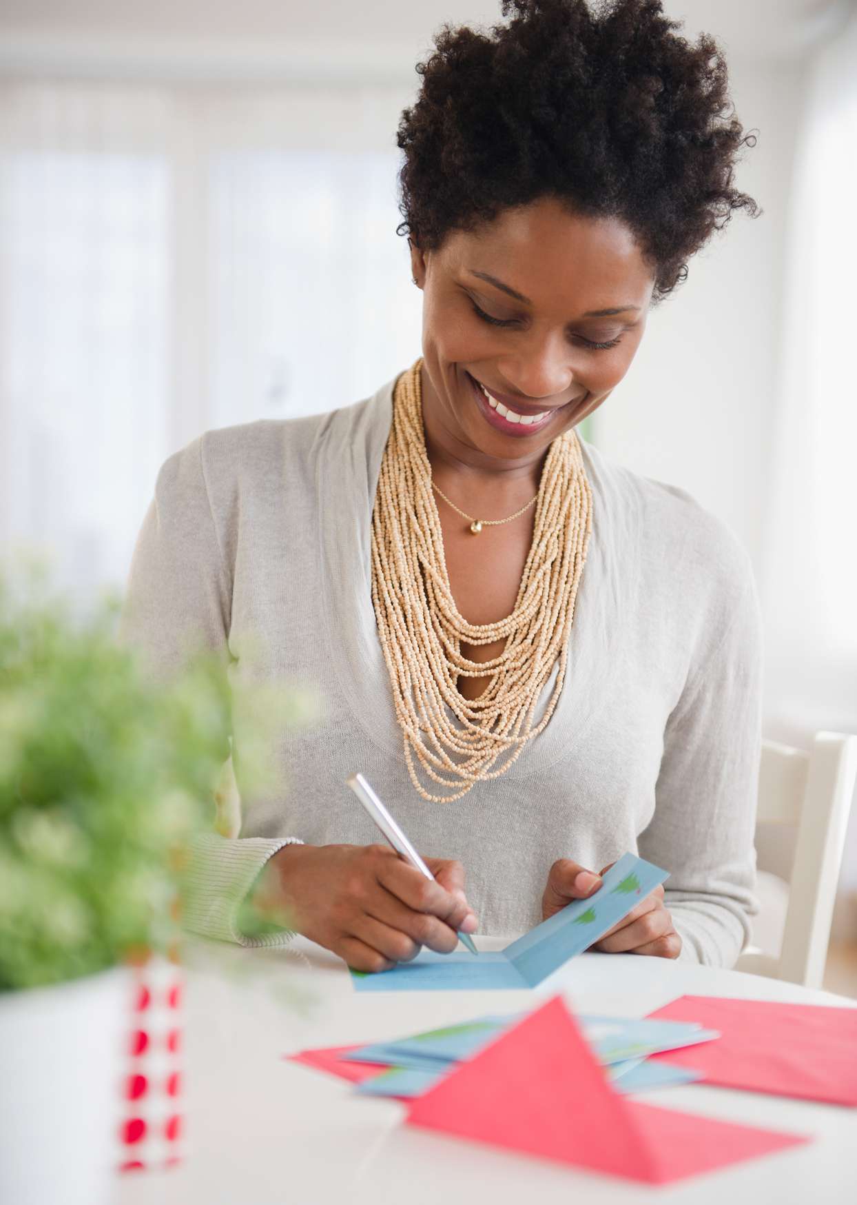 woman writing in blue holiday card