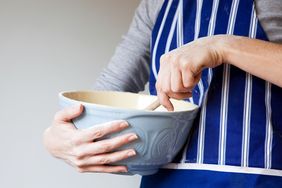 woman using spoon to mix butter and sugar