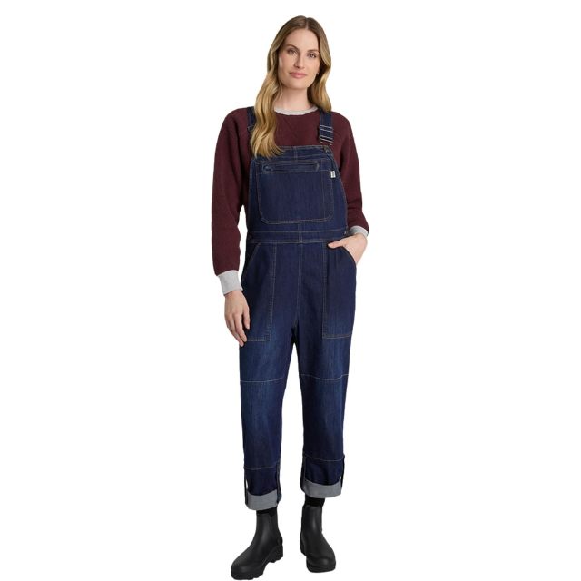Person wearing denim overalls and a sweater