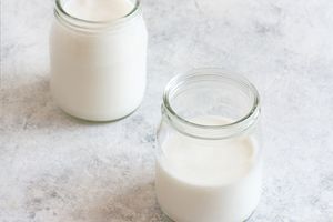 kefir in 2 glass jars on pale surface
