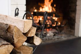 Stacked firewood near a burning fireplace