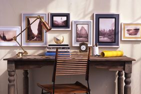 framed landscape photography hanging above writing desk