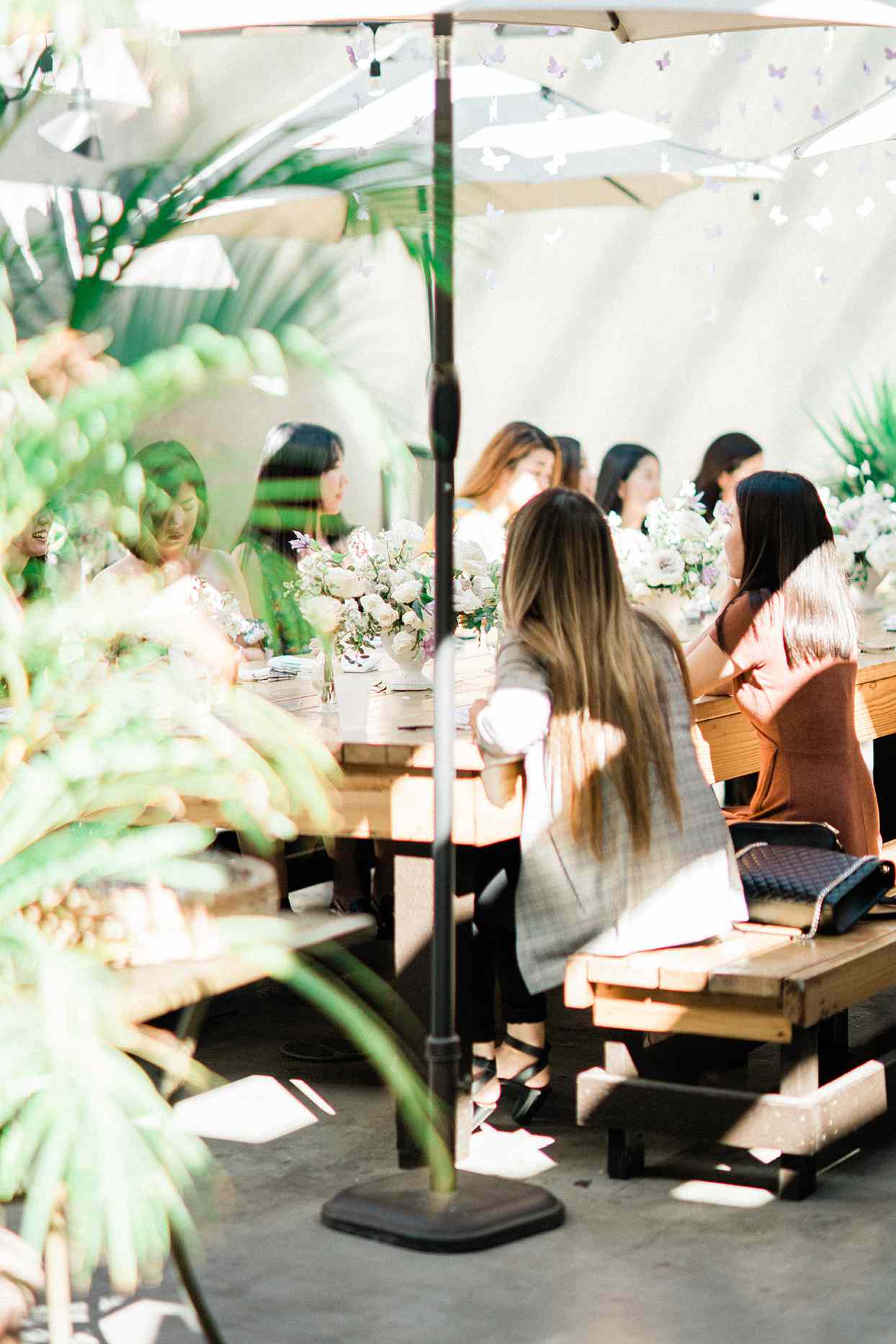 sally bridal shower sunlit tables with greenery, flowers, and umbrellas