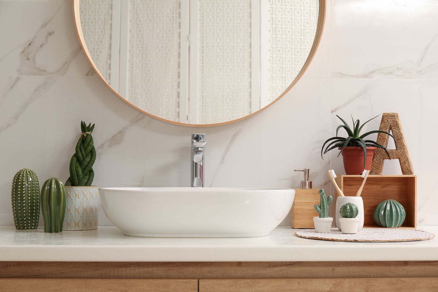 Bathroom vanity with plants round mirror and decorative accents