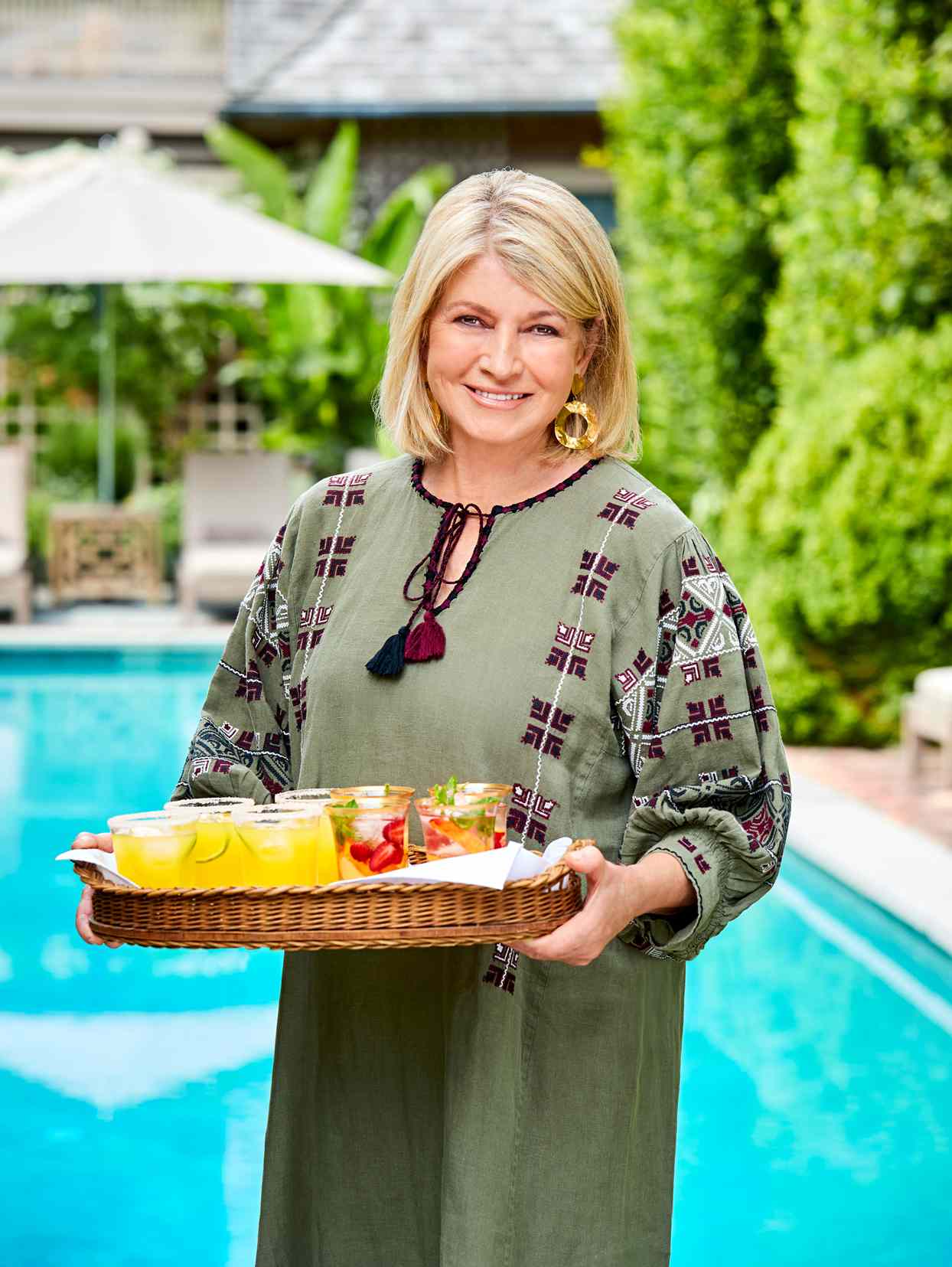 decorvow standing by pool holding cocktail tray