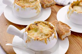 French onion soups served in ceramic bowls accompanied by pieces of bread on the side