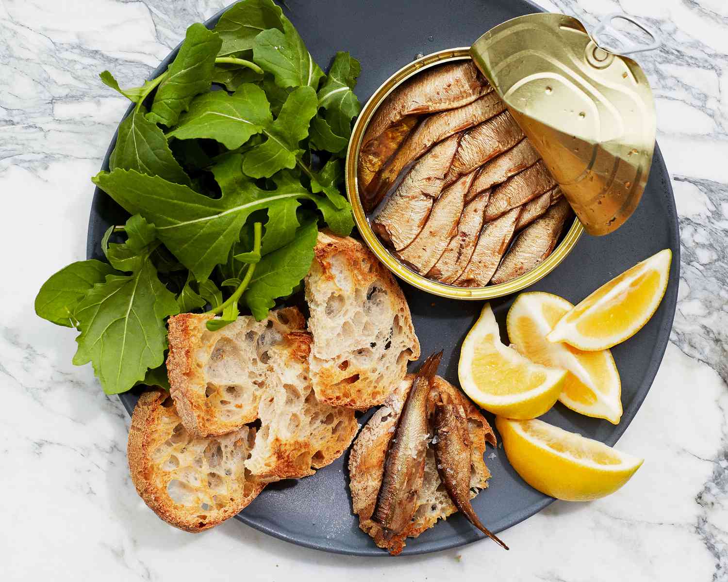tinned fish with toasts, arugula, and lemon