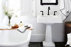black and white bathroom with claw foot tub and pedestal sink