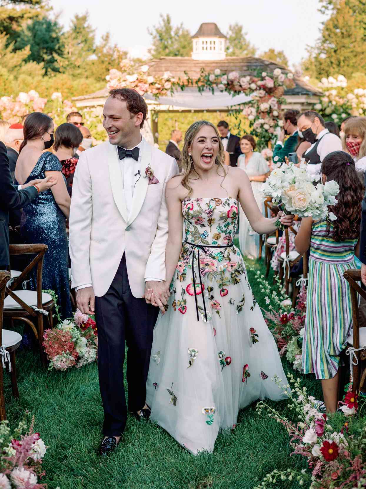 bride and groom recessing at floral wedding ceremony