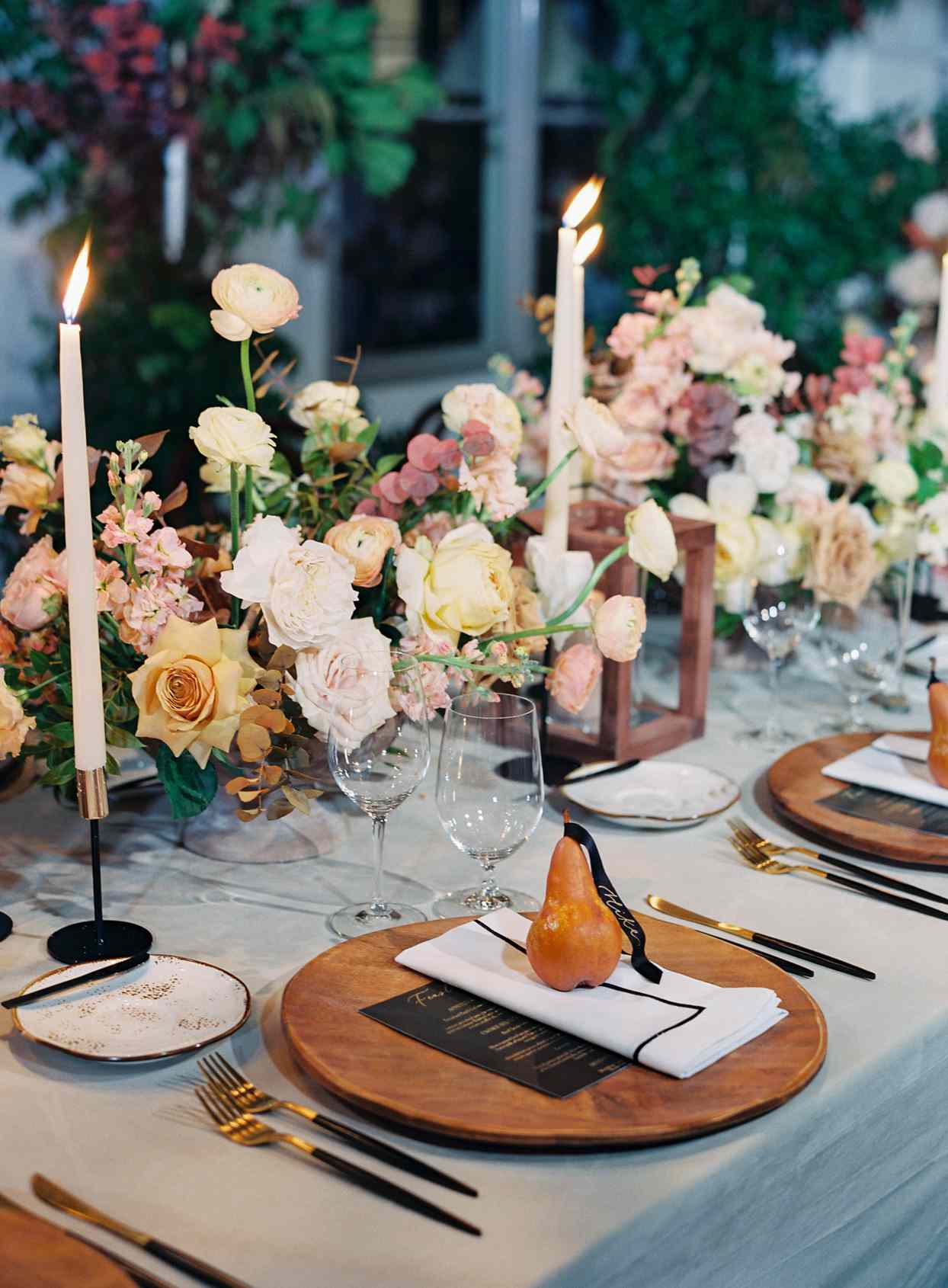table setting with wooden chargers and pear with name on ribbon