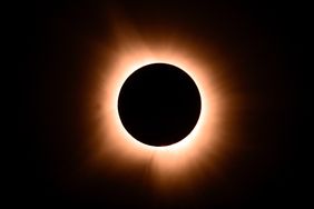 The moment of a total solar eclipse with a glowing corona visible