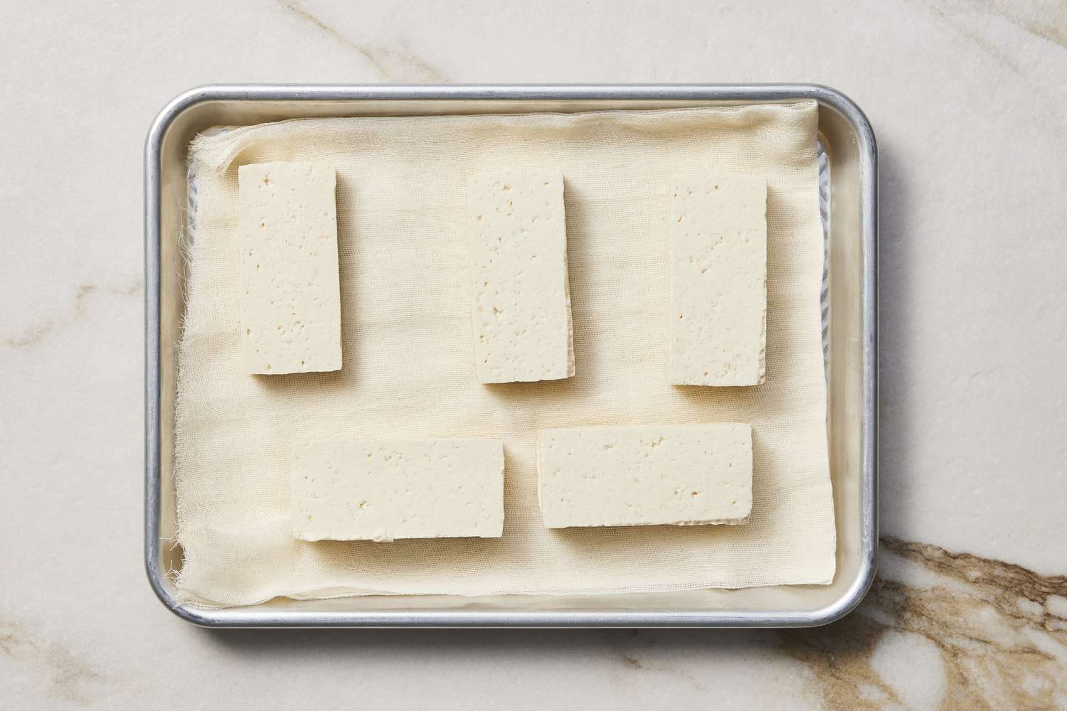 Tofu on baking sheet with paper towel