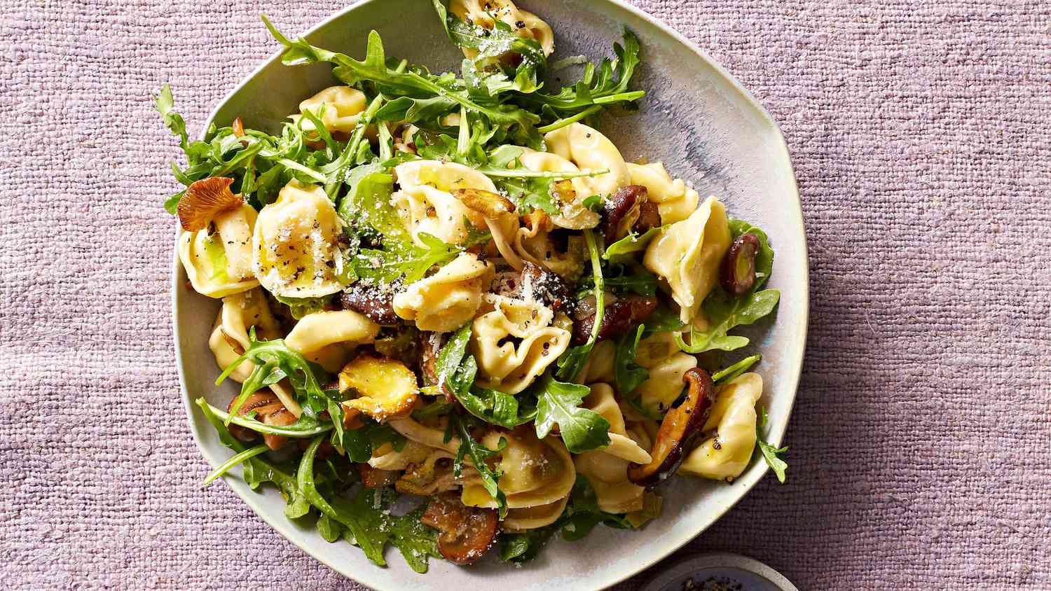 mushroom tortellini with arugula on plate