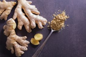 pieces of fresh ginger root and a spoon holding powdered ginger