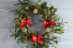 Christmas wreath with mistletoe on wood board
