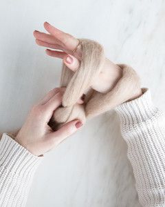 hand looping yarn around other hand for arm knit blanket