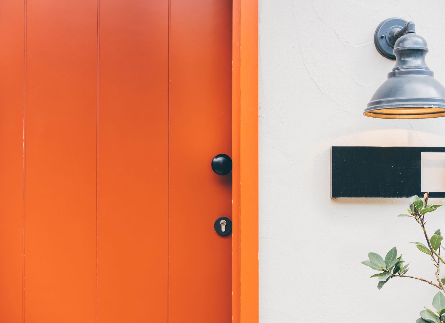 orange front door of a home close up
