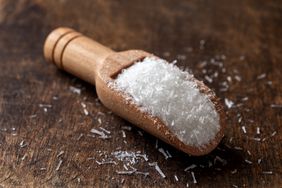 msg in a wooden scoop on wooden surface