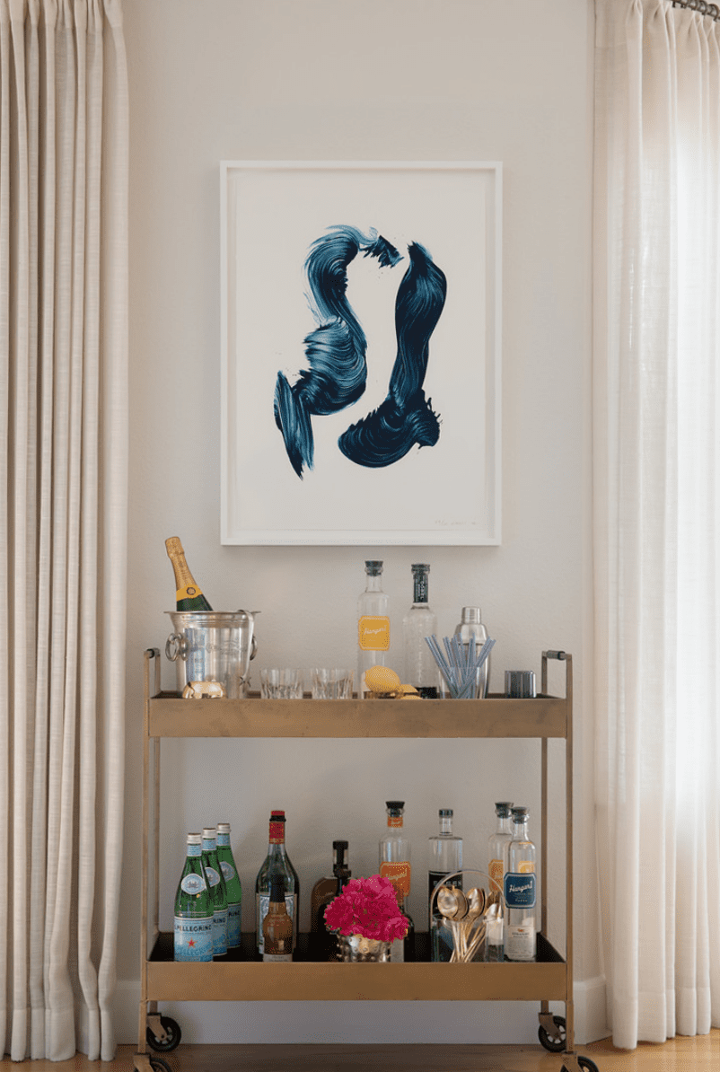 living room with metallic bar cart and abstract art