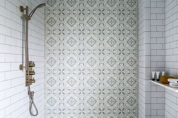 Tiled shower and hand help facucet in bright bathroom with vintage style