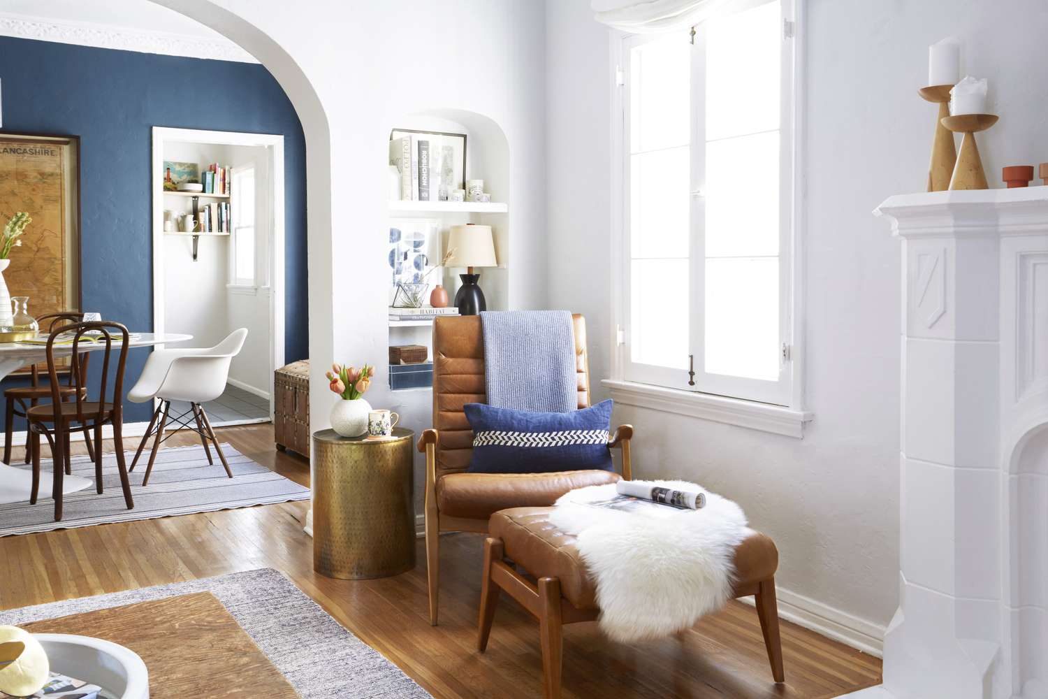 A cozy living room setup featuring a leather armchair with an ottoman surrounded by a modern and neatly decorated interior