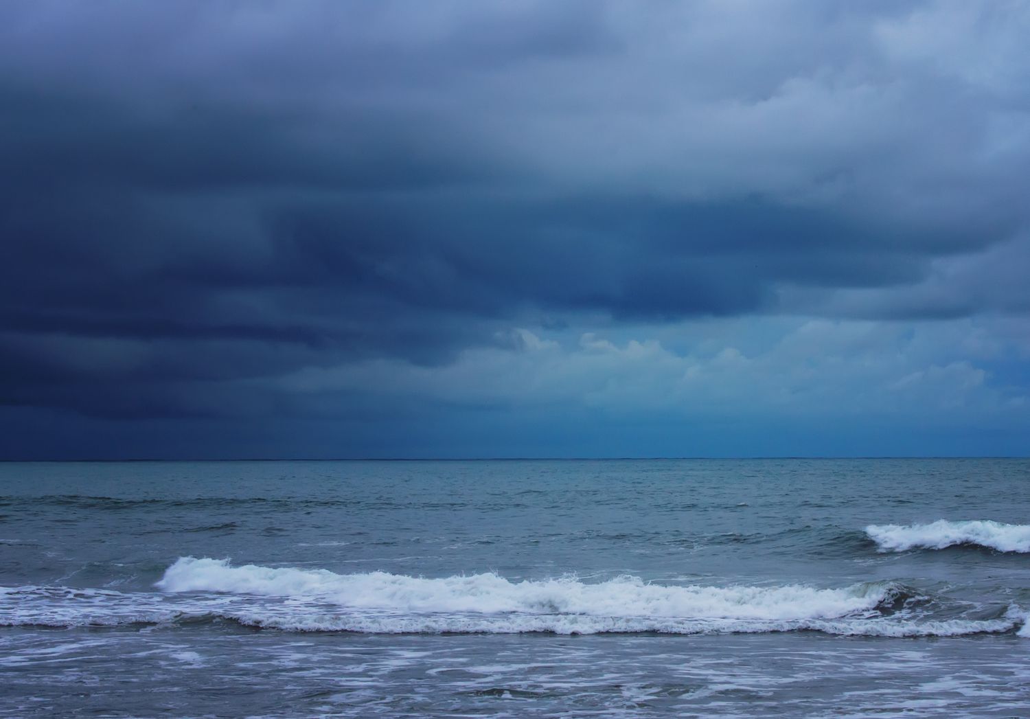 Waves on a beach under cloudy skies