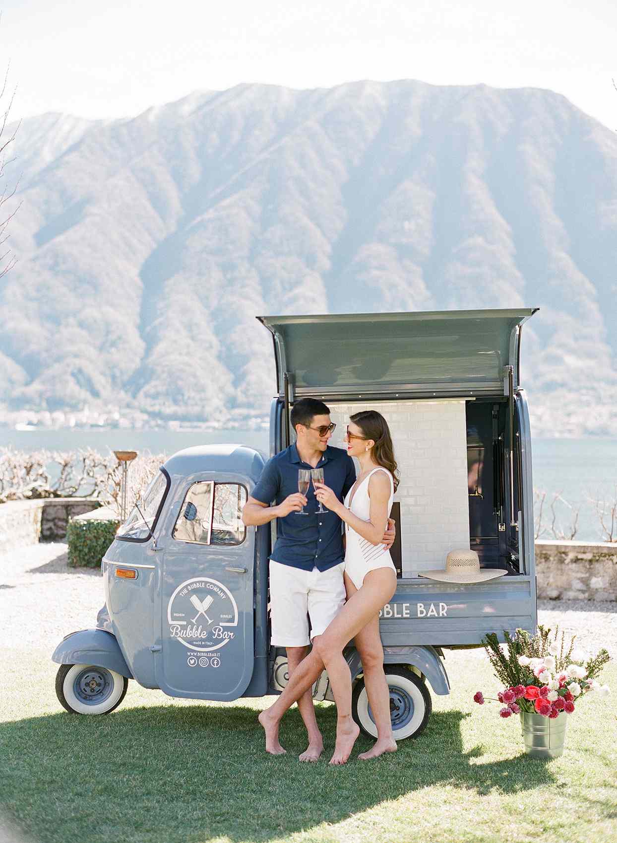 couple with champagne in front of bubble bar vehicle