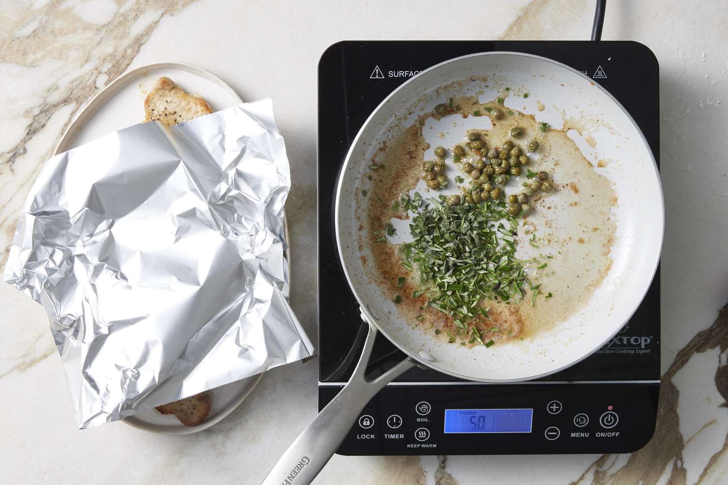 Frying pan with herbs and capers in oil
