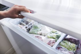 Woman hand opening freezer door