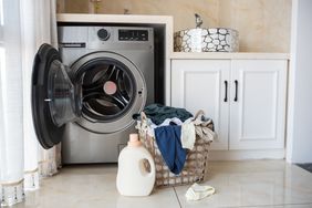 basket with laundry and washing machine