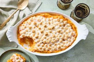 Sweet potato casserole with marshmallow topping in a dish with a serving missing