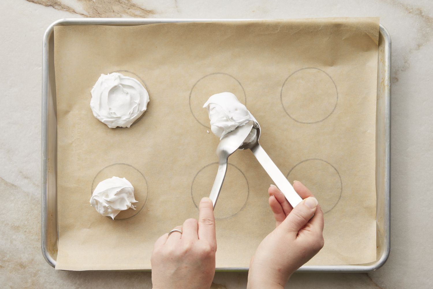 Meringue being spooned onto baking sheet