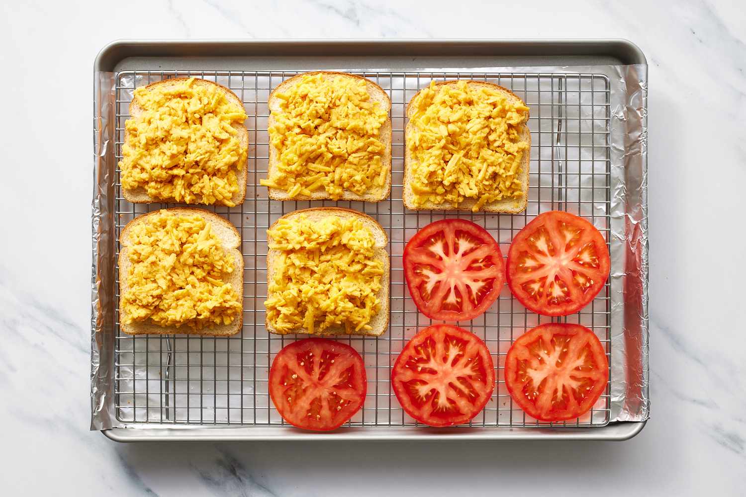 Tomato, cheese, bread on baking sheet
