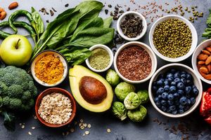 Assorted fresh produce, seeds, and spices displayed in bowls and scattered around