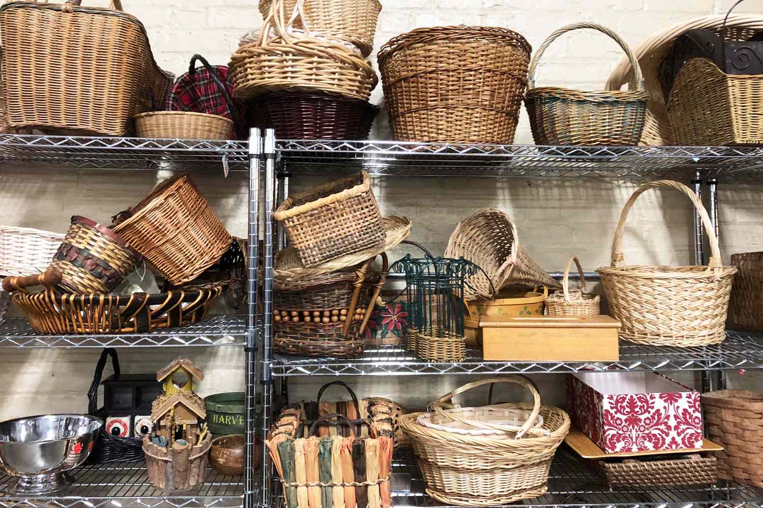 A collection of woven baskets of various styles and sizes arranged on metal shelves