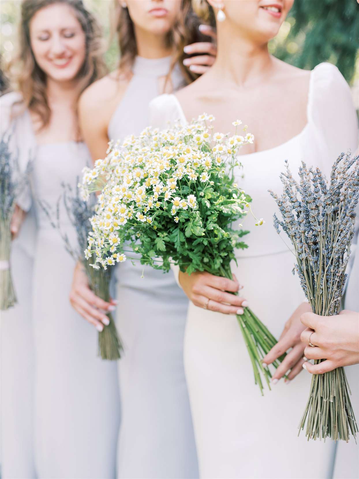 bridesmaids in pastel blue holding wildflowers