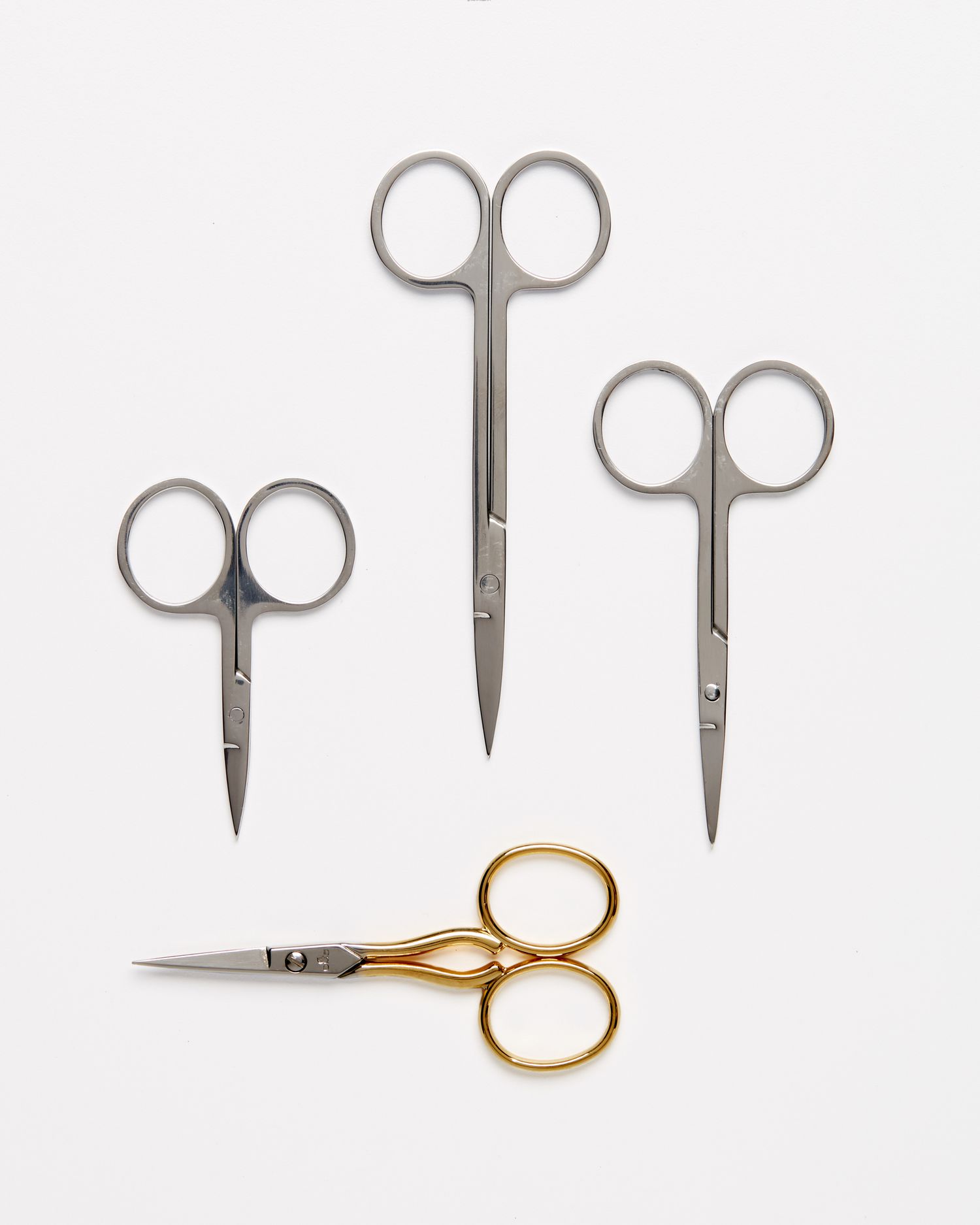 four types of embroidery scissors against a white background