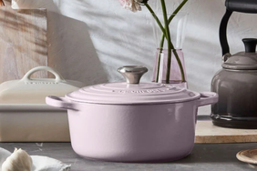 Lidded cookware on a kitchen counter next to other kitchen items