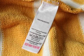 A detailed clothing care label attached to a yellow textile fabric