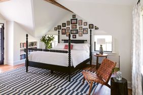 master bedroom with black spool bed and sloped ceilings