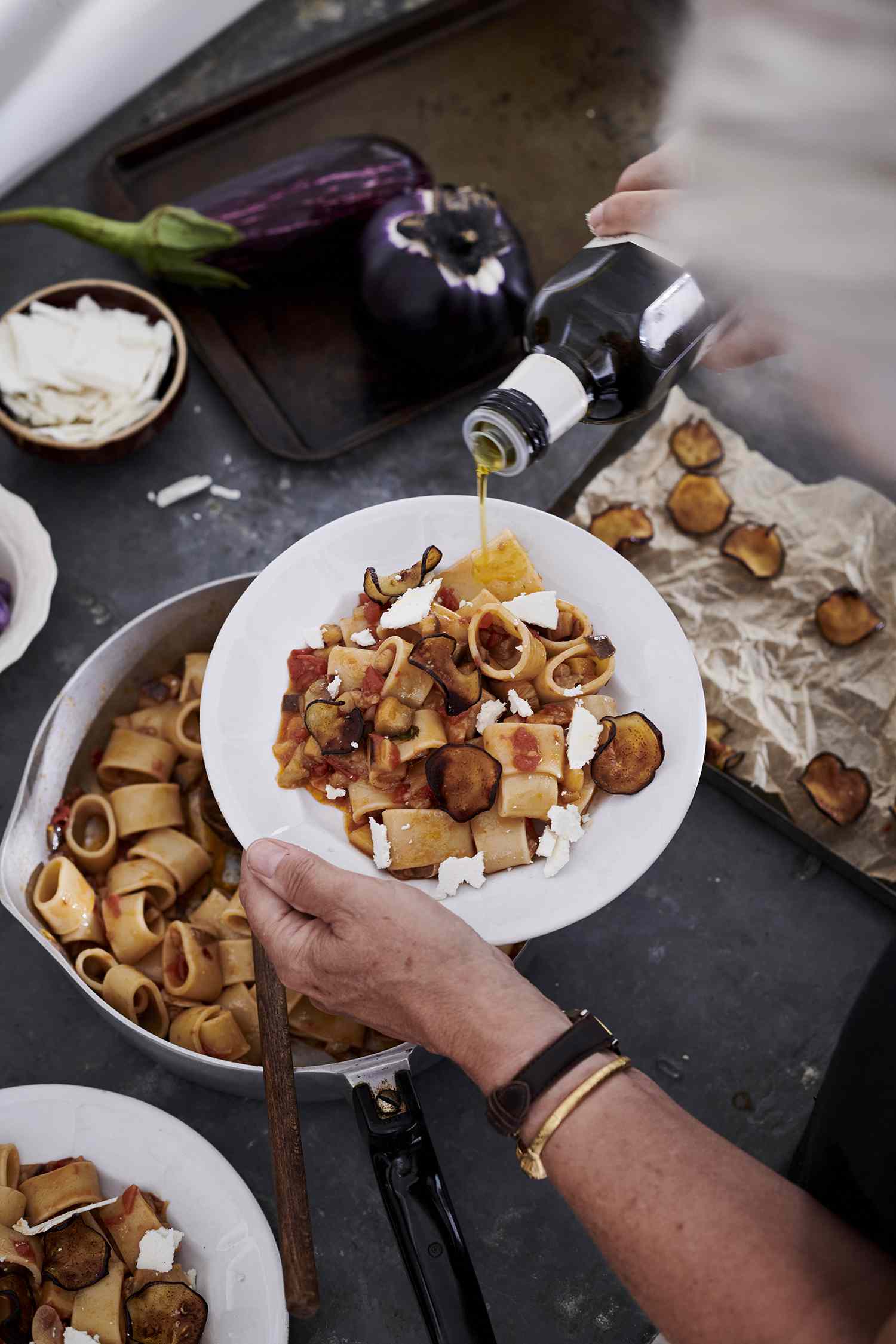 pasta all norma being drizzled with olive oil
