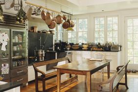 Rustic kitchen with hanging pots wooden table and benches