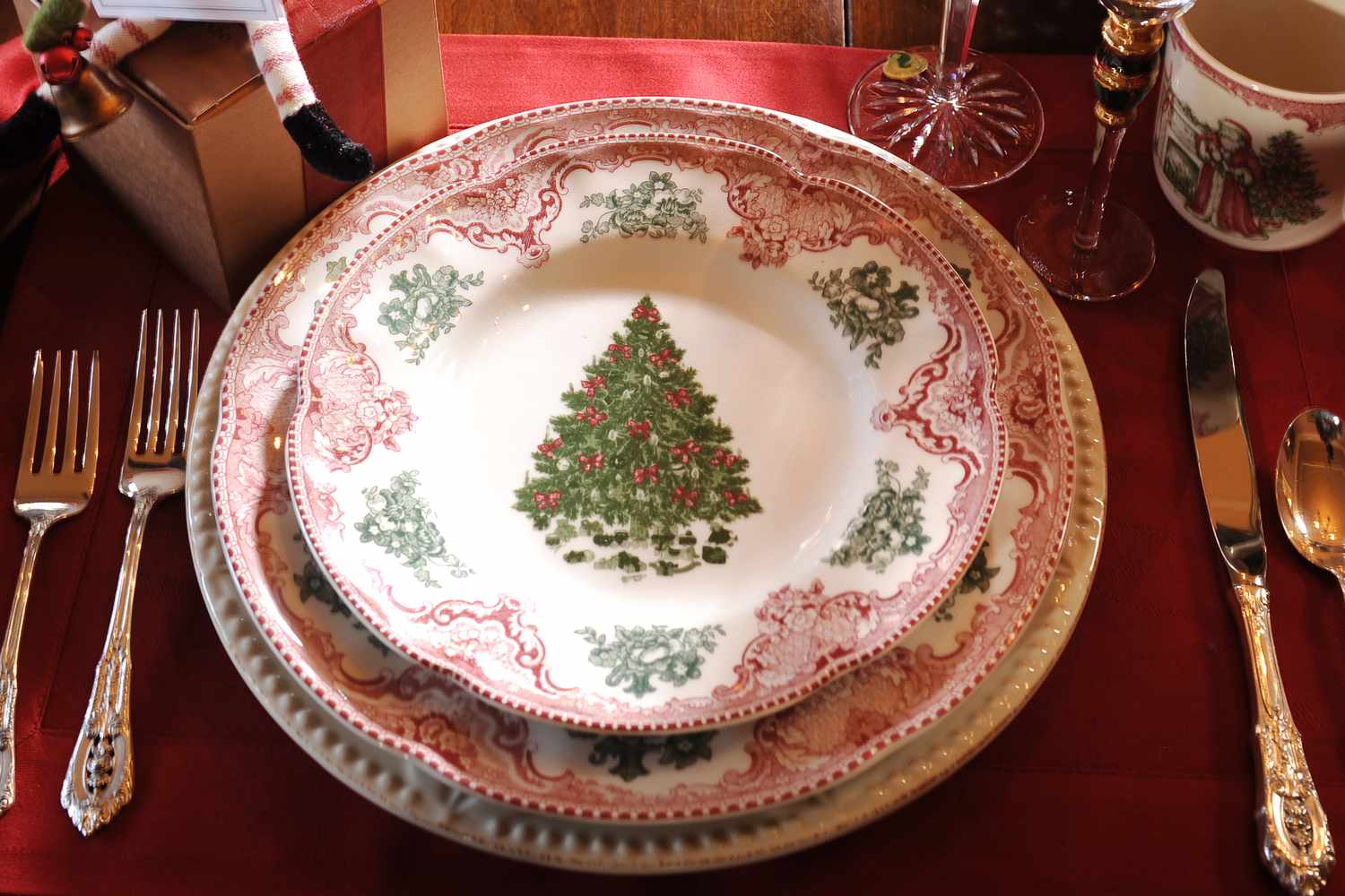 Festive dining table setting featuring plates with a Christmas tree design